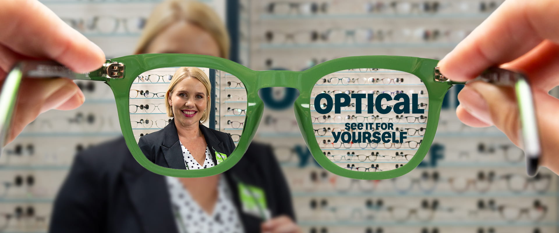 Optical - Hero image showing pair of glasses with clear view of an optician, whilst outside the glasses is blurred