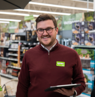 Colleague smiling with a clipboard.
