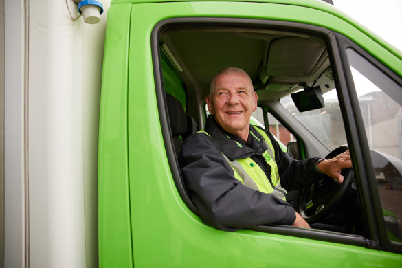 Delivery colleague smiling through window of lorry