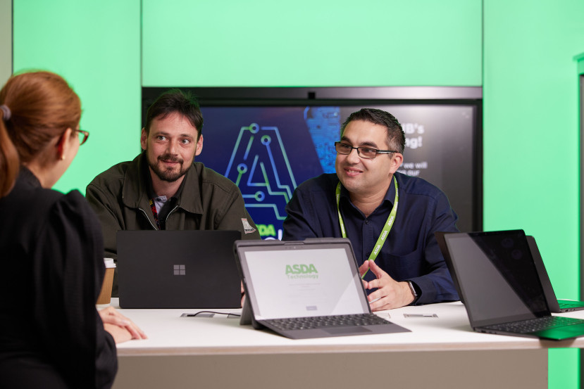 Colleagues having a conversation over laptops