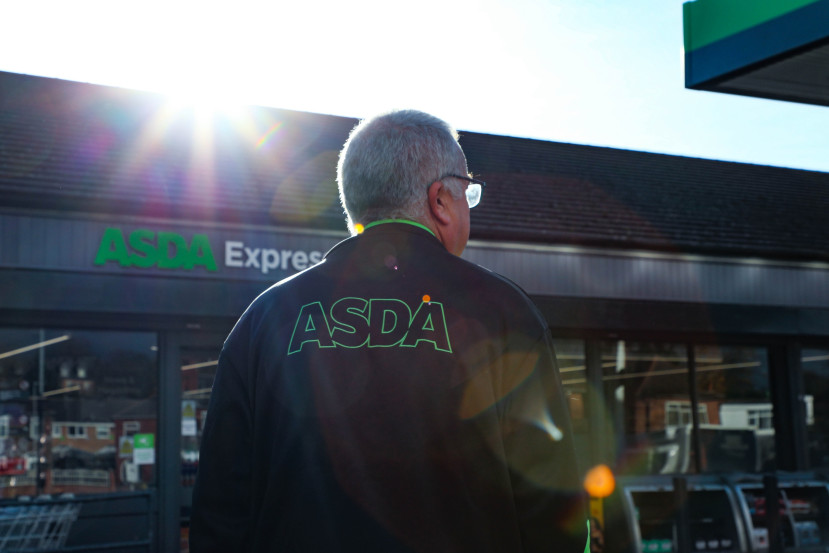Asda Express colleague walking towards store with sun setting behind