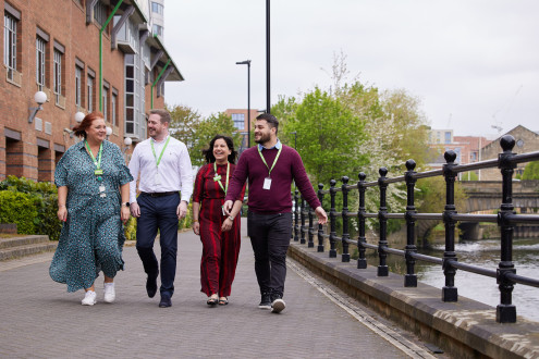Colleagues walking to offices beside river