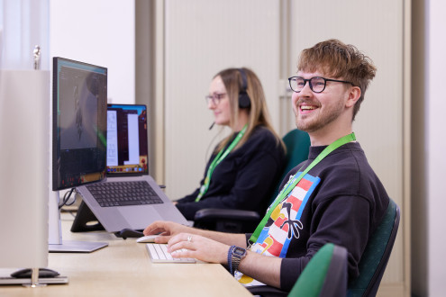 Colleagues smiling whilst working at computers