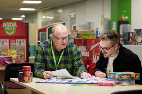 Asda design team discussing designs over a table