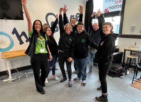 Group of colleagues smiling and celebrating with raised arms