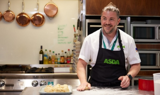 Bakery colleague dusting work surface with flour