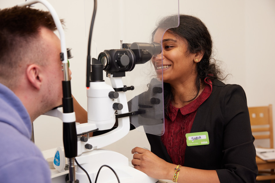 Optical colleague performing vision check on customer