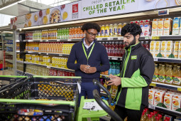 Retail colleagues filling baskets from shelves in store