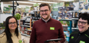 Three colleagues smiling with clipboards.